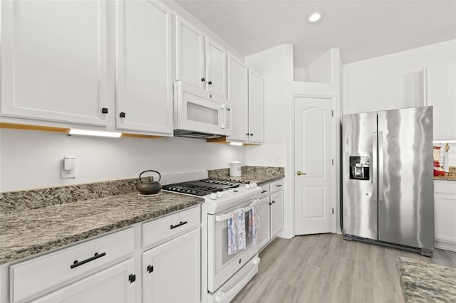 kitchen featuring light hardwood / wood-style floors, white cabinetry, light stone counters, and white appliances