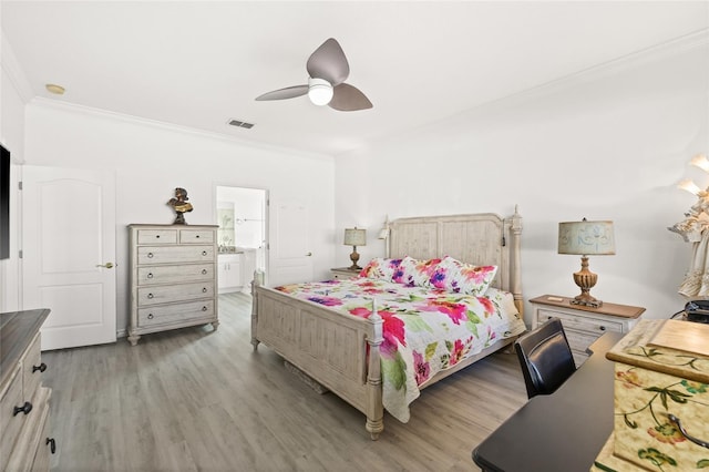 bedroom with light wood-type flooring, ensuite bath, ceiling fan, and ornamental molding