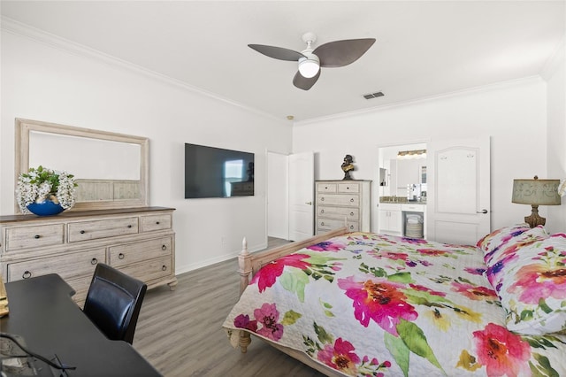 bedroom with hardwood / wood-style flooring, ceiling fan, ornamental molding, and connected bathroom