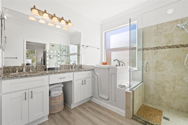 bathroom with vanity, hardwood / wood-style flooring, plenty of natural light, and crown molding