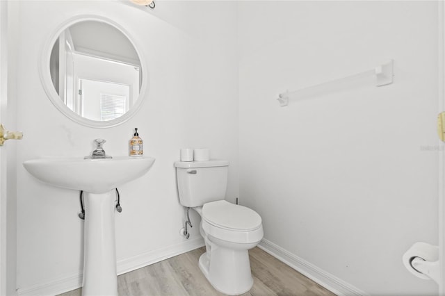 bathroom with hardwood / wood-style floors and toilet