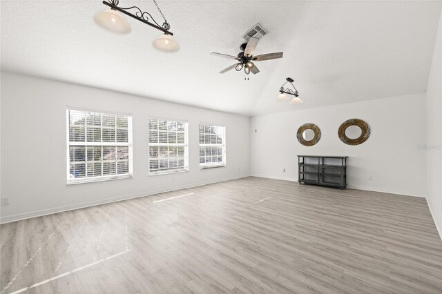 unfurnished living room with a textured ceiling, ceiling fan, hardwood / wood-style floors, and lofted ceiling