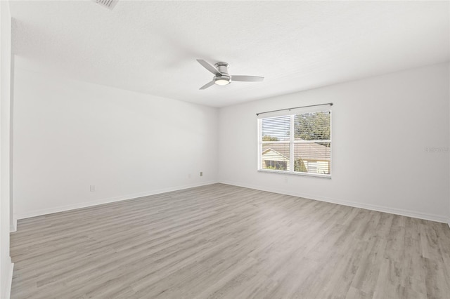 spare room with a textured ceiling, light hardwood / wood-style flooring, and ceiling fan