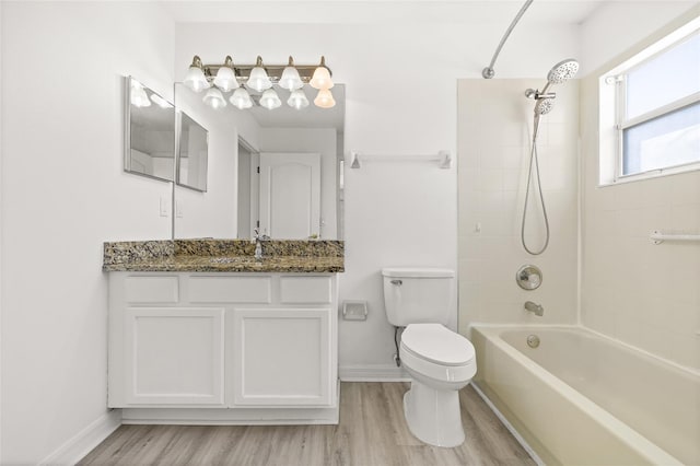 full bathroom featuring hardwood / wood-style floors, vanity, toilet, and tiled shower / bath