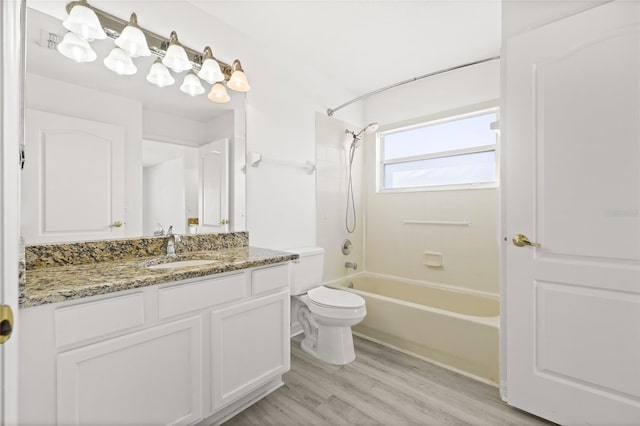 full bathroom featuring vanity, toilet, washtub / shower combination, and hardwood / wood-style flooring