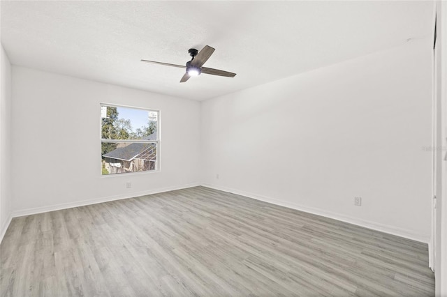 spare room with ceiling fan, light hardwood / wood-style floors, and a textured ceiling