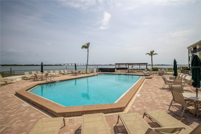 view of pool with a water view and a patio area