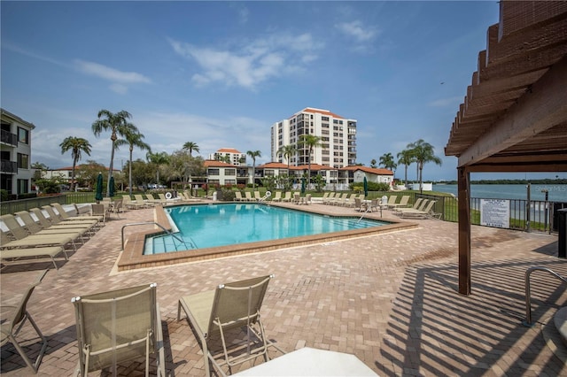 view of pool with a water view and a patio