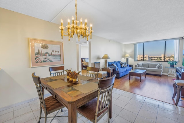 dining room featuring a textured ceiling, light hardwood / wood-style flooring, and a notable chandelier