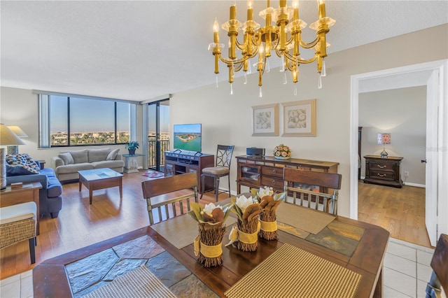 dining area featuring floor to ceiling windows, light hardwood / wood-style floors, and an inviting chandelier