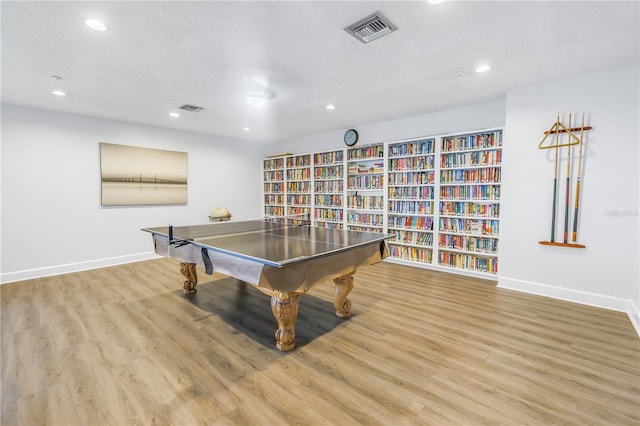 game room featuring a textured ceiling and light hardwood / wood-style flooring