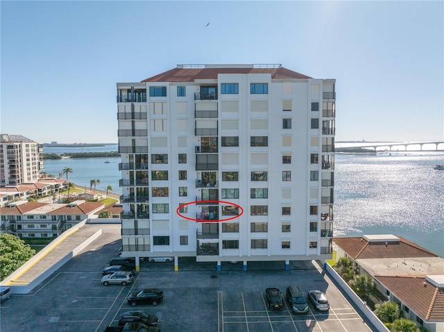 view of property with a water view and uncovered parking