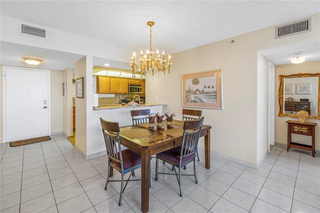 dining room with light tile patterned floors, a chandelier, and visible vents