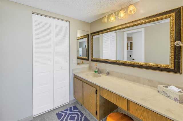 bathroom featuring vanity, a closet, and a textured ceiling