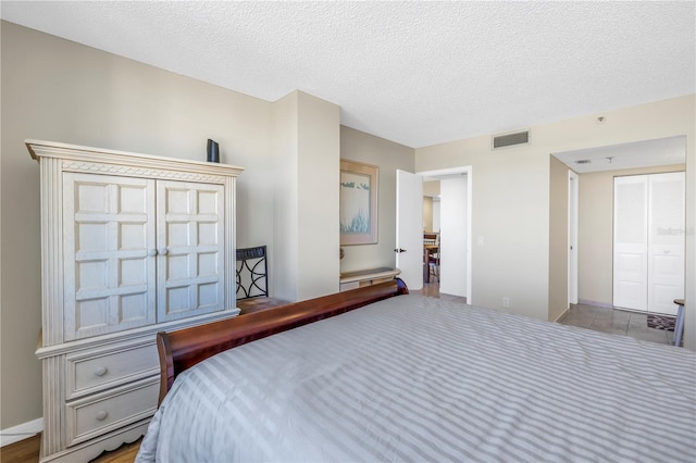 bedroom with a textured ceiling and visible vents