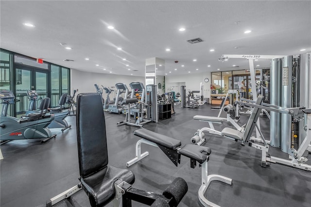 workout area featuring recessed lighting, expansive windows, and visible vents