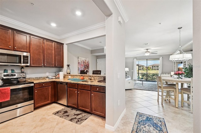 kitchen with ceiling fan, light stone counters, pendant lighting, appliances with stainless steel finishes, and ornamental molding