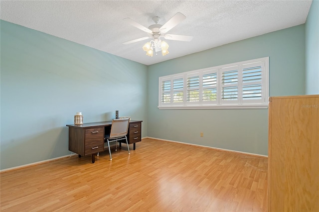 home office with a textured ceiling, light hardwood / wood-style flooring, and ceiling fan