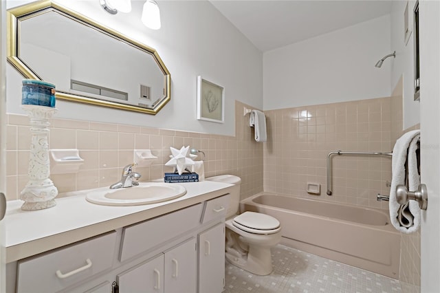 full bathroom featuring vanity, tile patterned floors, tiled shower / bath combo, toilet, and tile walls