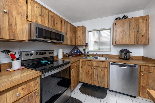 kitchen featuring light tile patterned flooring, sink, and appliances with stainless steel finishes