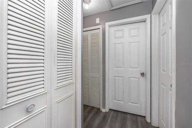 hall featuring dark hardwood / wood-style floors and a textured ceiling