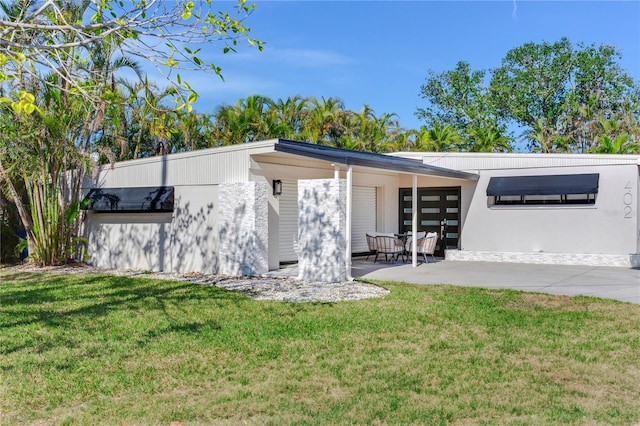 rear view of house with a patio area and a yard