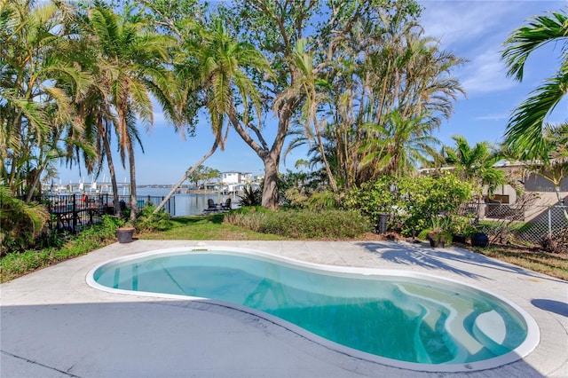 view of pool with a water view and a patio