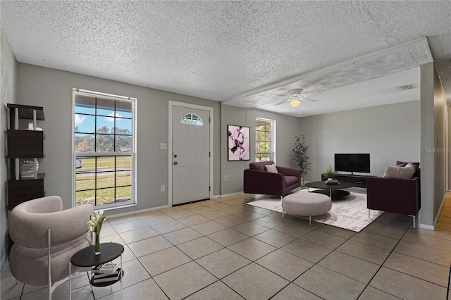 tiled living room featuring a textured ceiling and ceiling fan