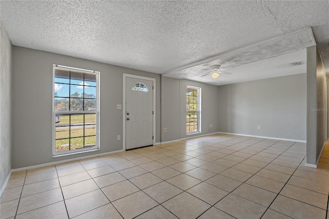 tiled entrance foyer with a textured ceiling, plenty of natural light, and ceiling fan