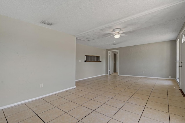 spare room featuring ceiling fan, a textured ceiling, and light tile patterned floors