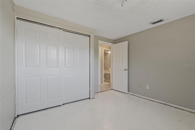 unfurnished bedroom featuring a closet and a textured ceiling