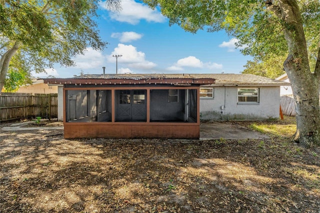 rear view of property featuring a patio area and a sunroom