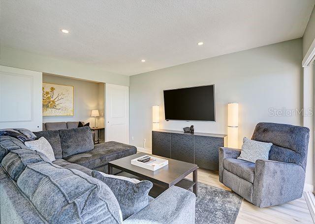 living room with a textured ceiling and light wood-type flooring