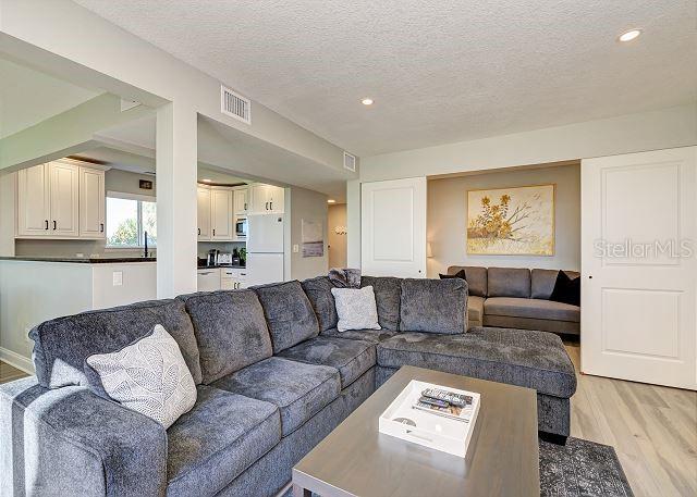 living room featuring light hardwood / wood-style flooring and a textured ceiling