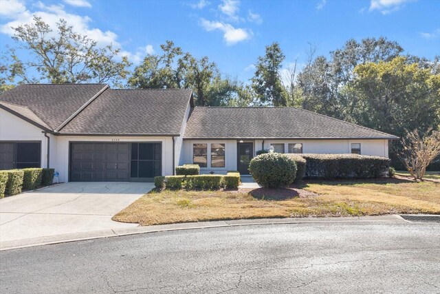 single story home featuring a front lawn and a garage