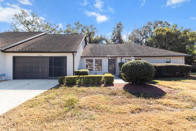 ranch-style home with a front yard and a garage