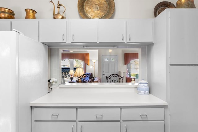 kitchen featuring white cabinets and white refrigerator