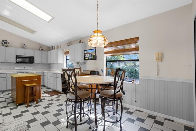 dining room with plenty of natural light and vaulted ceiling