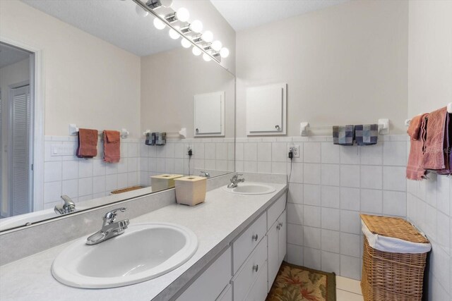 bathroom with vanity, tile patterned floors, and tile walls