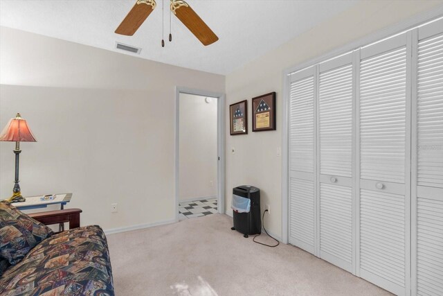 sitting room with light colored carpet and ceiling fan