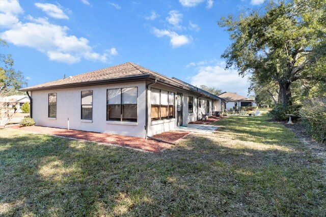 view of side of home with a yard