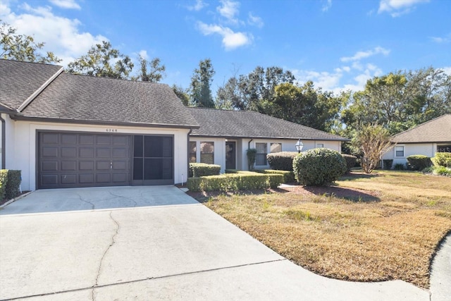 single story home with a garage and a front lawn