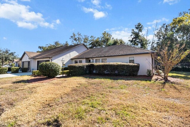 ranch-style house featuring a front yard and a garage