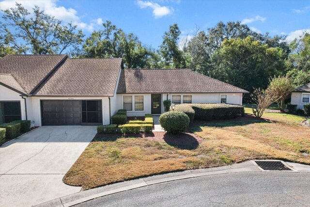 ranch-style house with a front yard and a garage