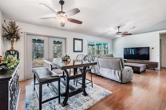 dining space featuring plenty of natural light, light hardwood / wood-style floors, lofted ceiling, and french doors