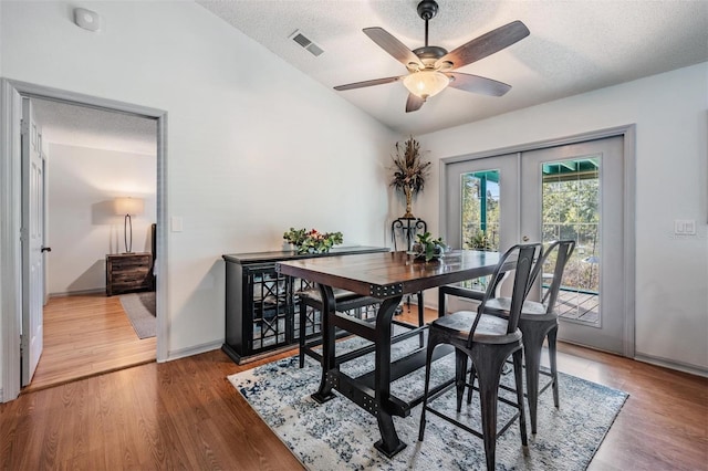 dining area featuring french doors, a textured ceiling, hardwood / wood-style flooring, and ceiling fan