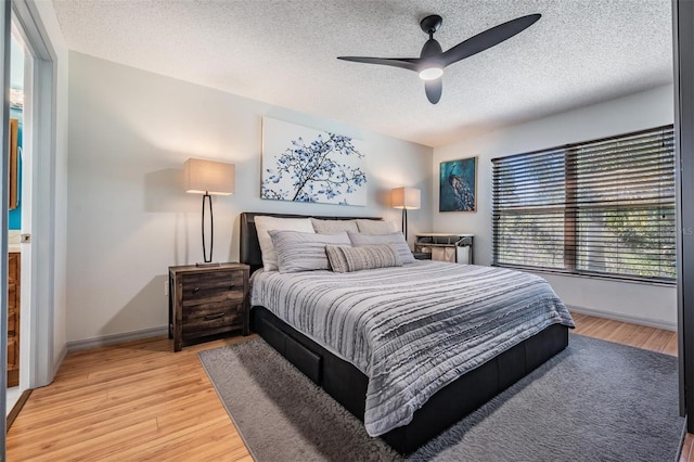 bedroom featuring hardwood / wood-style floors, a textured ceiling, and ceiling fan