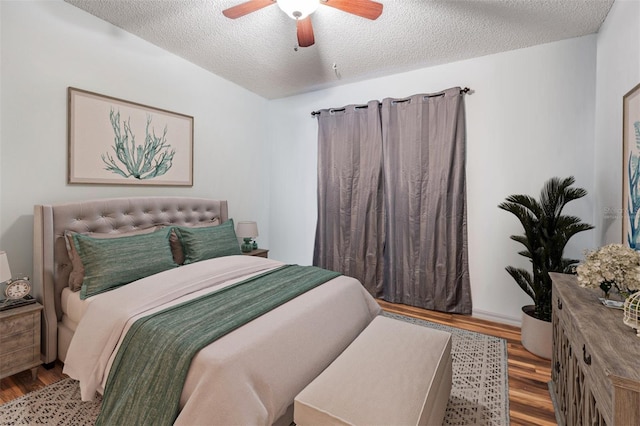 bedroom featuring ceiling fan, a textured ceiling, and wood finished floors