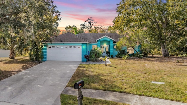 view of front facade featuring stucco siding, an attached garage, concrete driveway, and a front lawn