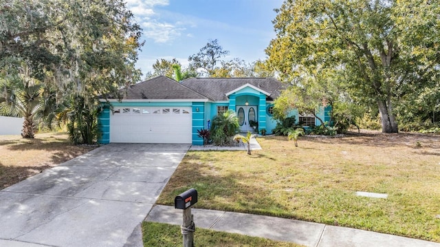 view of front of property with stucco siding, driveway, an attached garage, and a front lawn